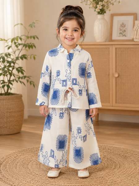 Girl wearing a white and blue floral printed full sleeve top with matching wide-leg pants co-ord set by Kidaura.